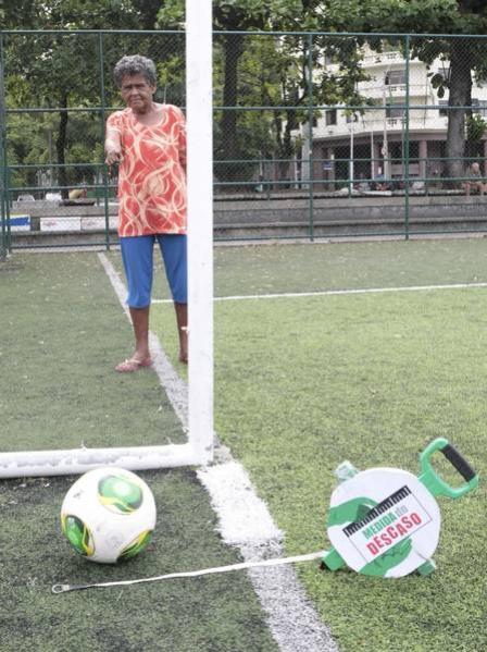 Dona Maria, 70 anos, aponta para o gol