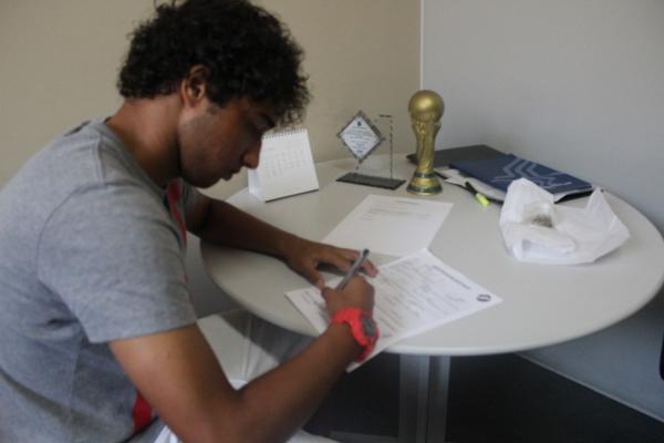 Hugo Borges assinando seu primeiro contrato profissional