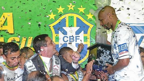 Presidente do Paulista na poca, Palhares observa o zagueiro Anderson Batatais com a taa de campeo