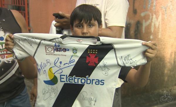 Pequeno Carlos Neto exibe sua camisa autografada