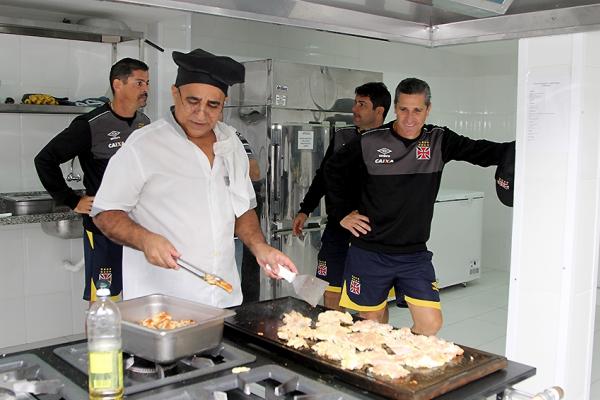 Cozinheiro prepara a comida observado por Jorginho, Valdir e Joelton