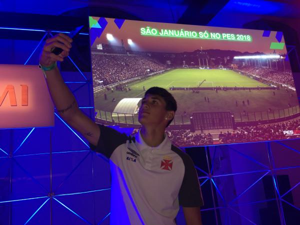 Mateus Vital tira selfie com o painel que exibe São Januário no PES 2018
