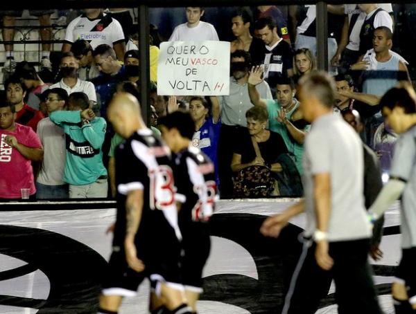 Torcedor ergue faixa em meio  sada cabisbaixa de time e comisso