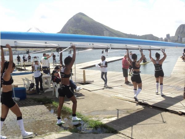 Meninas do four skiff carregam para a gua antes da prova