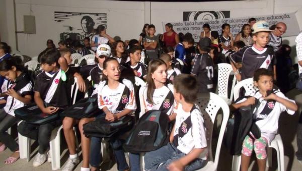Crianada exibe orgulhosa as camisas e os kits escolares do Vasco da Gama que receberam por terem sido bons alunos 
