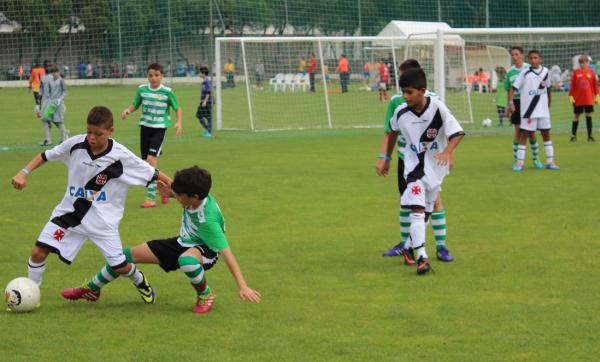 O atacante Pedrinho faz bonita finta sobre adversrio enquanto  observado pelo lateral-direito Gutierres.