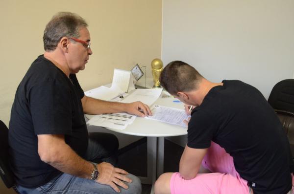 Renato Kayzer assinando contrato sob olhares de Antnio Jos Teixeira