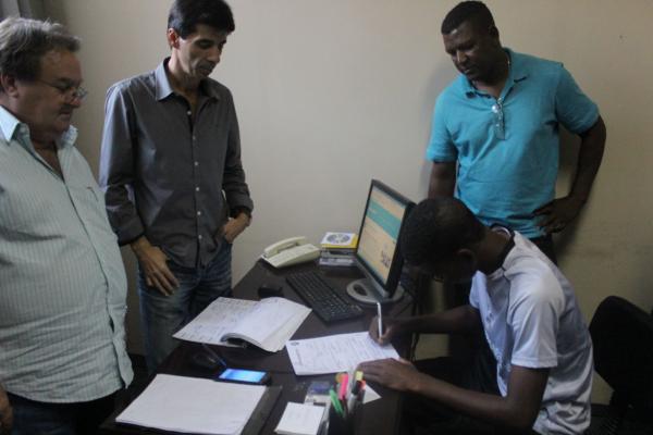 Alan assinando seu primeiro contrato profissional