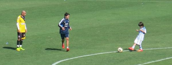 Matias, de casaco azul, e Lucas, com o uniforme principal, brincam com o pai aps o treino