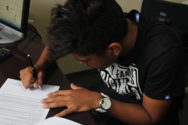 Evander assinando seu primeiro contrato profissional