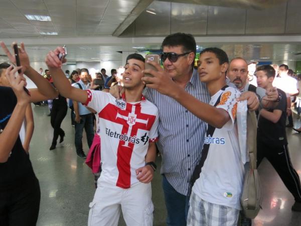 Joel posa para duas fotos ao mesmo tempo no desembarque do Vasco em Braslia nesta sexta