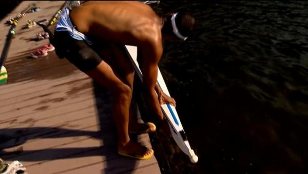 Remadores se esforam para retirar barco da lagoa com nvel baixo de gua 
