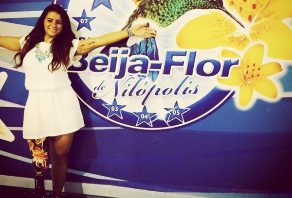 Camille posa orgulhosa ao lado de smbolo da Beija-Flor