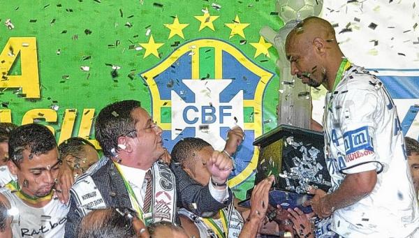 Presidente do Paulista na poca, Palhares observa o zagueiro Anderson Batatais com a taa de campeo