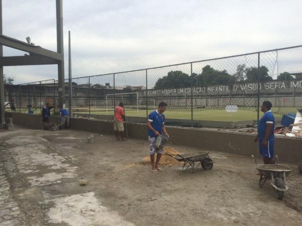 Funcionrios trabalham na construo do muro que delimita a rea do campo anexo de treinos
