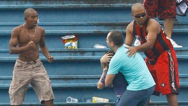 Pai tenta proteger o filho em meio a briga de torcedores