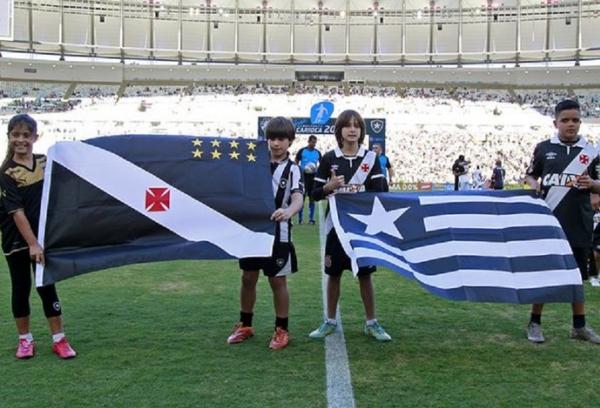 Crianas seguram bandeiras adversrias na entrada no campo