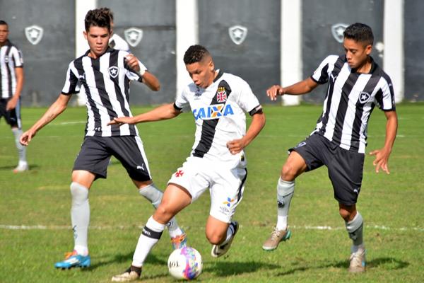 Paulinho domina a bola entre dois marcadores