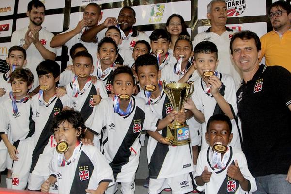 Meninos mordem medalha e exibem trofu com orgulho