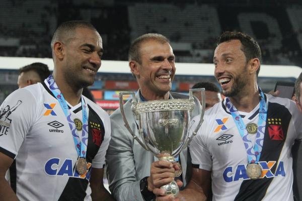 Milton Mendes segura a taa ao lado de Rodrigo e Nen