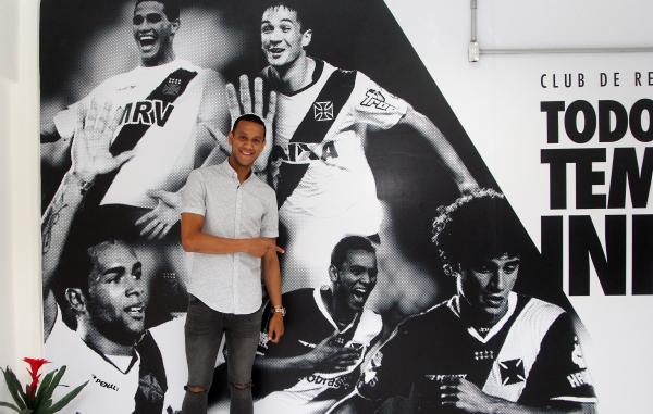 Souza posa ao lado de um painel que exibe sua foto no Caprres/Base