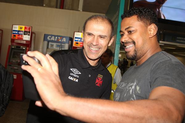 Técnico Milton Mendes posa para selfie no desembarque