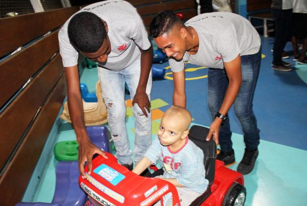 Eric Pimentel e Edvélton, ambos do sub-15, se divertem com o pequeno Erik