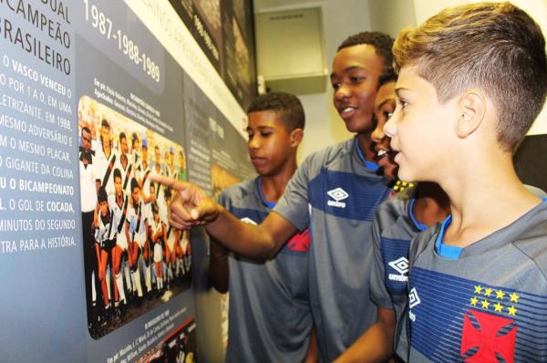 Pequenos vascaínos observam imagens expostas na sala de imprensa do clube