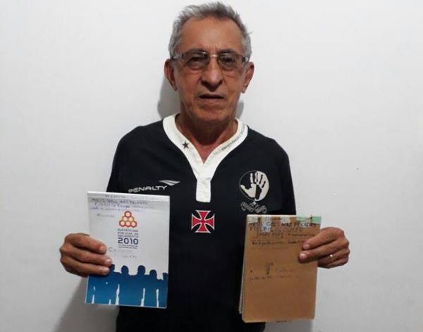 Antônio Sarin segurando as cadernetas que têm registrado os seus mais de 3000 mil gols