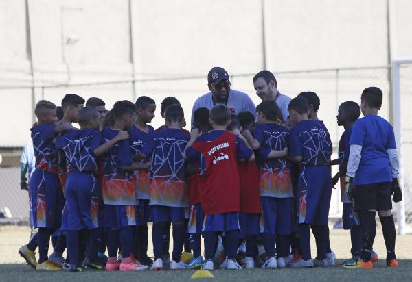 Garotada escuta as orientações do treinador