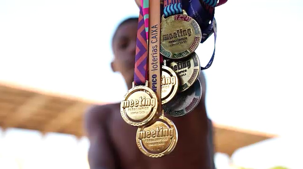 Luan Felipe segura medalhas que já conquistou na natação — Foto: Franciane Dahm