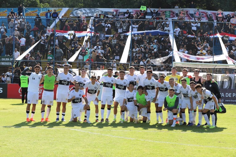 Jogadores do Olimpia posam com os torcedores ao fundo, após a vitória contra o Recoleta FC, na penúltima rodada do torneio Apertura de 2026.